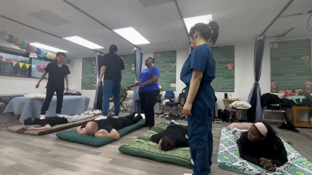 AMOM students and an instructor learning practical bodywork together in the classroom